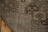 Distressed charcoal and silver pile of the vintage Ersari carpet revealing its sturdy hand-knotted back.