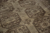 Textured pile of distressed Ersari carpet, showing silver, charcoal, and ivory floral gul motifs.