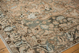 Distressed pile of a vintage Persian Baktiari rug, showing scrolling vinery in sand and dusty teal.
