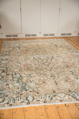 Vintage distressed Baktiari carpet close-up: faded ivory, blue, teal palmettes and vinery.