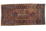 Vintage Heriz runner, brick red field, three bold medallions, primitive florals, and abrash.