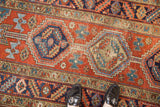 Vintage Heriz runner with geometric medallion, primitive florals, abrash, and worn pile.