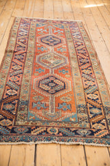 Vintage Heriz runner with geometric medallion, primitive brick red, navy, aqua floral motifs and abrash.