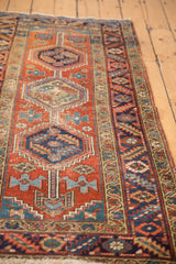 Heriz runner detail: brick red, navy geometric medallion and primitive floral motifs.