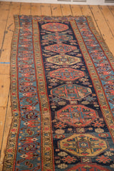 Worn navy field geometric guls in red, saffron, and sky blue Malayer runner.