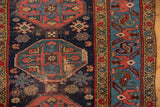 Detail of vintage Malayer rug's geometric guls, navy ground, sky blue border, and visible foundation.