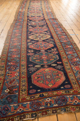 Aged vintage Malayer runner, showing repeating geometric guls in navy, red, and gold.