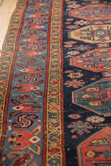 Malayer rug border detail: repeating guls and geometric floral motifs in navy, red, gold.