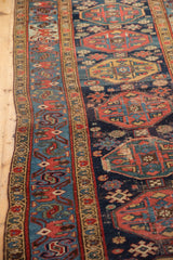 Repeating guls, starburst motifs on navy Malayer runner's worn hand-knotted pile.