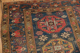 Geometric guls and starburst motifs in rich blues, reds, and golds on Malayer runner pile.
