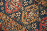 Vintage Malayer runner detail showing navy, red, saffron geometric guls and visible foundation.