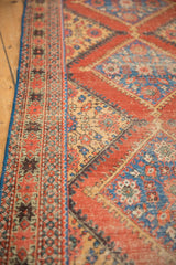 Antique Persian Mahal runner: intricate side border, worn pile, red, blue, beige diamond patterns.