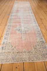 Distressed Sparta runner's secured end, revealing hard wear, blush, denim, and ivory tones.