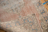 Distressed Sparta rug showing hard wear, blush tones, and secured hand-knotted foundation.