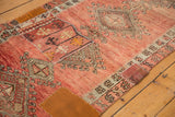 Textured blush and dusty rose Oushak rug detail, with artistic patchwork and faded geometric motifs.