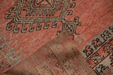 Folded distressed Oushak runner shows blush, silver geometric pattern, and kilim reinforcement.