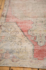 Distressed rug pile with faded arabesque motifs in cherry red, saffron, and charcoal.