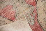 Vintage distressed Oushak rug's cherry red and saffron pile folded, exposing light foundation.