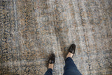 Distressed vintage Kashan carpet with even wear, featuring ivory, teal, and gold floral motifs.