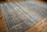 Distressed texture and faded floral motifs of a vintage hand-knotted carpet.