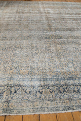 Distressed Kashan carpet showcasing intricate floral vinery, even wear, and soft ivory, teal, sand tones.