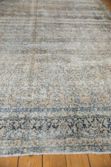 Distressed vintage Kashan rug displaying floral vinery in antique ivory and dusty teal.