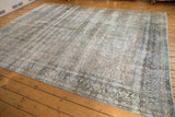 Distressed vintage Kashan carpet, even wear across knot heads, with muted ivory, teal, and gold florals.