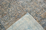 Distressed Kashan pile displaying even wear and faded floral motifs, alongside its woven foundation.