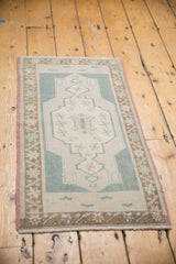 Distressed Oushak rug's central medallion with starburst florals and denim blue.