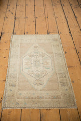 Distressed Oushak rug showcasing worn hexagonal medallion, pale blue floral motifs, and secured edge.
