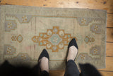 Distressed vintage Oushak rug showcasing stepped medallion, geometric patterns, and even worn pile.