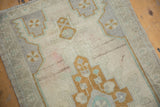 Close-up of vintage distressed Oushak rug, geometric stepped medallion in pale bronze, beige.