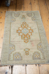 Distressed vintage Oushak rug bottom edge with geometric pattern and even pile wear.