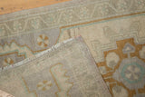 Distressed texture and geometric design on the hand-knotted back of this Vintage Oushak rug.