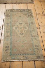Distressed Oushak runner corner with pale ocean green border and muted field motifs.