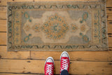 Vintage distressed Oushak rug displaying even wear, soft ivory, silver, and green tones.