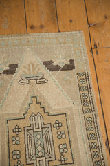 Geometric pattern detail with worn texture and original selvage on vintage Oushak rug.