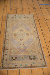 Distressed Oushak runner corner with mauve, dusty gold, and turquoise spandrel.