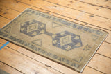 Distressed Turkish Oushak rug corner displaying time-softened geometric border and secure edge.