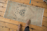 Distressed vintage Oushak runner rug with faded ivory, powder blue-green, and charcoal patterns.