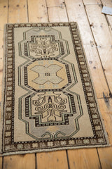 Distressed Oushak rug with pale gold tree of life motif, charcoal outlines, sea foam green accents.