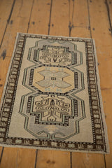 Distressed Oushak rug mat in muted tones, showing ram horn and tree-of-life medallions.