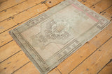 Blush border and charcoal pinwheel floral design on this distressed Oushak rug.