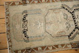 Distressed Turkish Oushak rug with heavy abrash, showing faded platinum and sea foam green motifs.