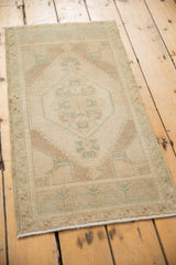 Corner of distressed Oushak rug, even wear on ivory field, pale sea foam green spandrel.