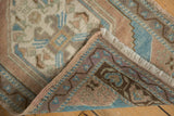 Vintage Oushak rug showing hand-knotted back, original side cord, and distressed pile.