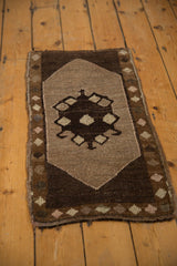 Hand-knotted Oushak rug mat with chocolate brown diamond medallion and original side selvage.