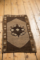 Lower right corner of the vintage Oushak rug showing even knot wear, geometric brown pattern, and intact side selvage.
