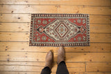 Rust Oushak rug mat with floral blossoms, distressed texture, and original side selvage.