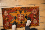 Textured distressed Oushak rug mat with brick red and tangerine geometric pattern.
